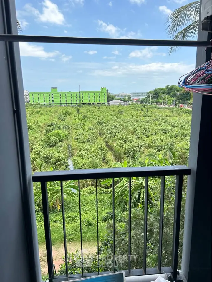 Stunning balcony view overlooking lush greenery and distant cityscape.