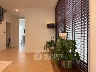 Stylish modern interior with wooden flooring and large window blinds, perfect for a cozy living space.
