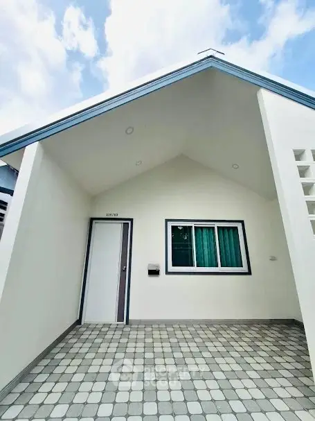 Charming modern house exterior with unique roof design and tiled entrance.