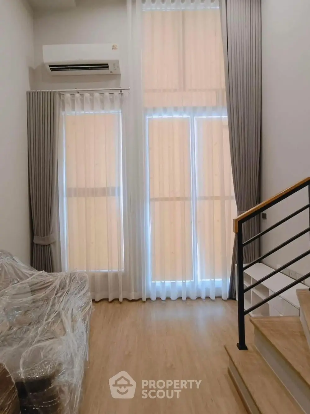 Spacious modern living room with unique architectural beams and large windows.