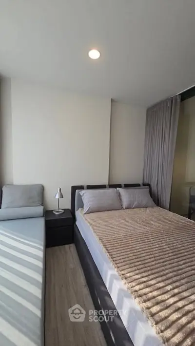 Modern bedroom with cozy bed and natural light in a stylish apartment.