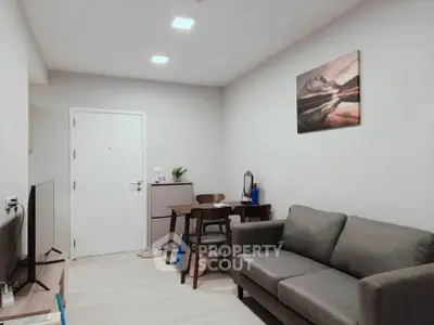 Modern living room with cozy gray sofa and dining area, perfect for relaxation and entertaining.