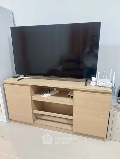 Modern living room setup with sleek TV stand and large flat-screen TV, perfect for entertainment.