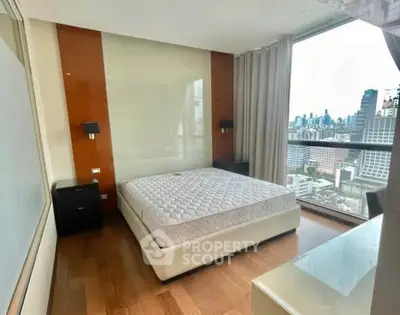 Spacious bedroom with city view in modern high-rise apartment