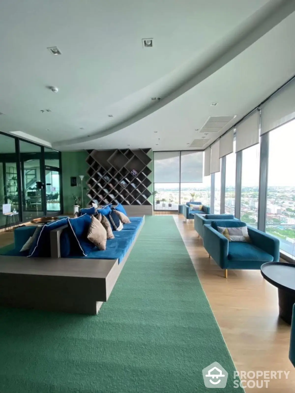 Luxurious modern living room with panoramic city views and stylish blue seating