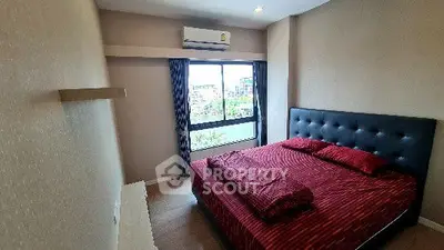 Cozy bedroom with modern decor and large window offering natural light.