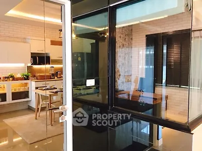 Modern kitchen with sleek design and dining area in open layout apartment.