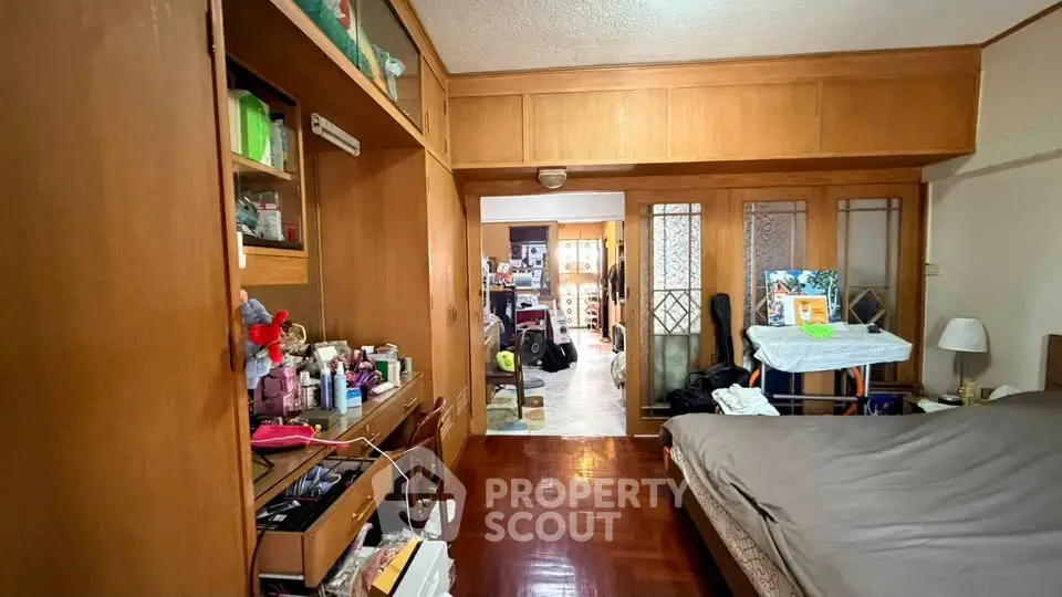 Cozy bedroom with wooden built-in storage and parquet flooring