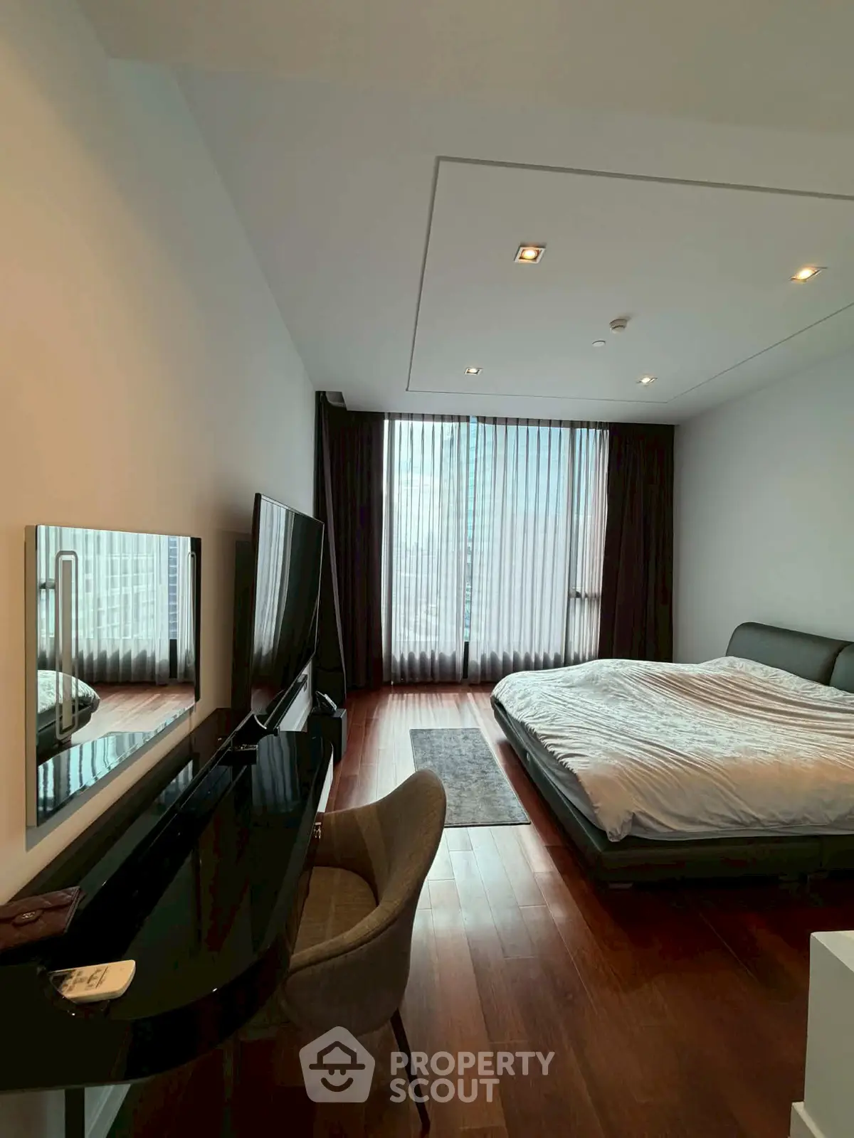 Spacious modern bedroom with large window and stylish furnishings