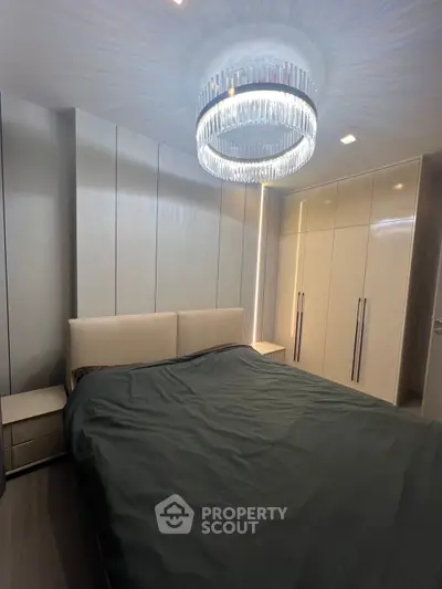 Luxurious bedroom with modern chandelier and sleek built-in wardrobes