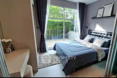 Spacious bedroom with large window and garden view, featuring modern decor and cozy ambiance.