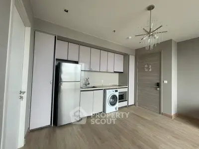 Modern kitchen with sleek appliances and stylish lighting in a contemporary apartment.
