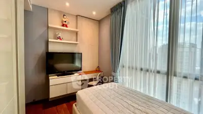 Modern bedroom with large windows and built-in desk, offering city views and ample natural light.