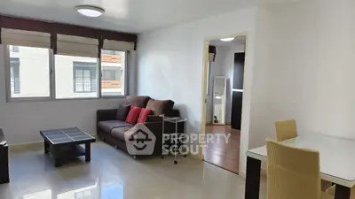 Spacious living room with modern furniture and natural light in a stylish apartment.