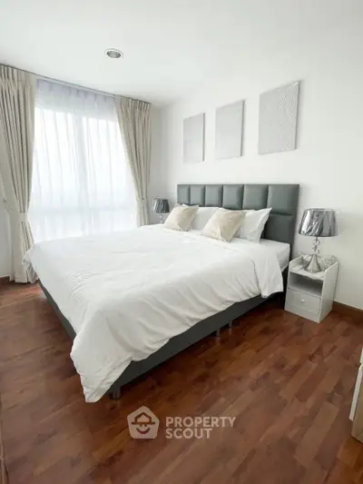 Elegant bedroom with modern decor and large window, featuring a comfortable bed and stylish lighting.