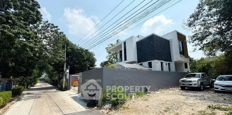 Modern architectural home with sleek design and spacious outdoor area in a serene neighborhood.