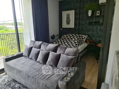 Stylish modern living room with plush gray sofa and cozy bedroom nook