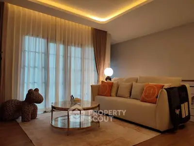 Elegant living room with cozy sofa, stylish lighting, and floor-to-ceiling curtains.