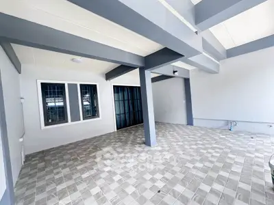 Spacious covered patio with modern tiled flooring and sleek design, perfect for outdoor gatherings.