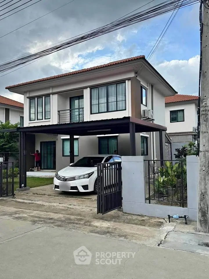 Modern two-story house with carport and landscaped front yard in suburban neighborhood.