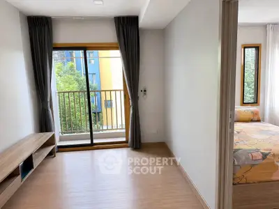 Bright bedroom with wooden flooring and balcony access in modern apartment