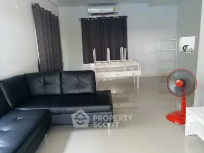 Spacious living room with black leather sofa and modern decor