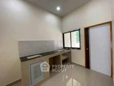 Modern minimalist kitchen with sleek countertops and ample natural light.