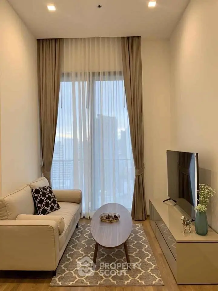 Modern living room with elegant decor, featuring a cozy sofa, stylish coffee table, and large TV, perfect for relaxation.