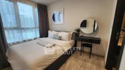 Cozy bedroom with modern decor and large window in urban apartment