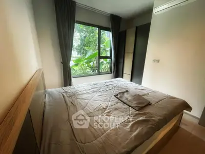 Cozy bedroom with large window and lush greenery view, featuring modern furnishings and neutral tones.