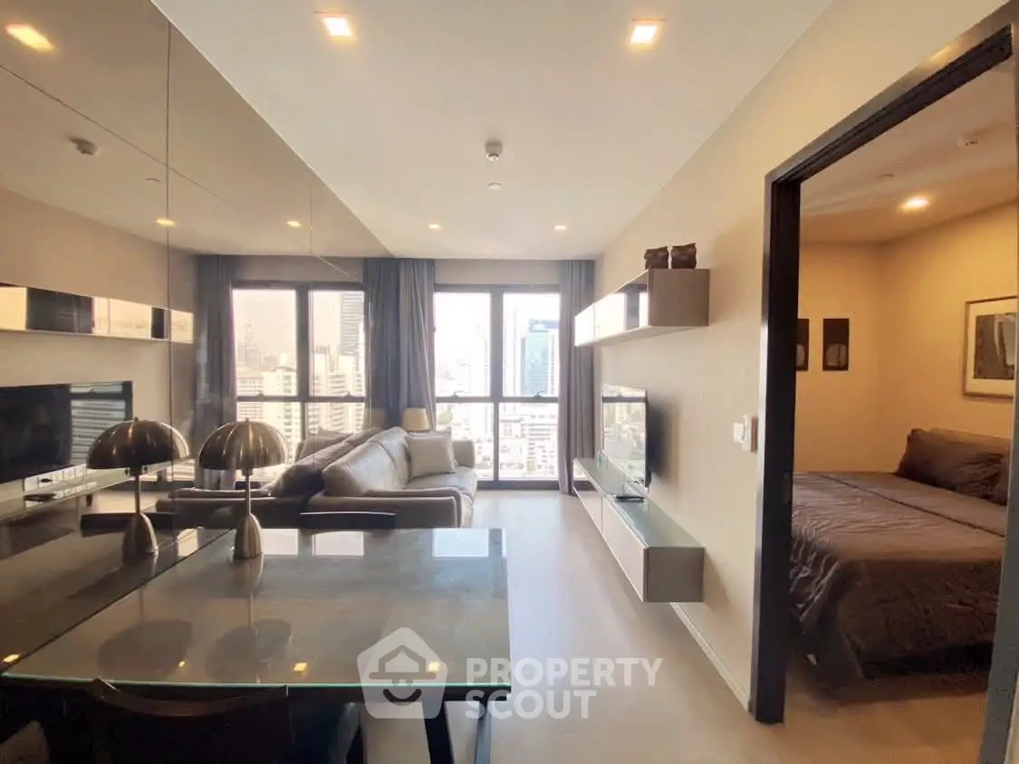 Modern apartment with open living room and bedroom, featuring city views and stylish decor.