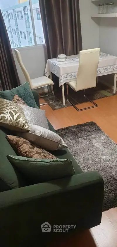 Cozy living room with elegant dining area and plush green sofa