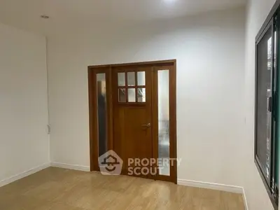 Minimalist room with wooden door and frosted glass panels, ideal for modern interiors.