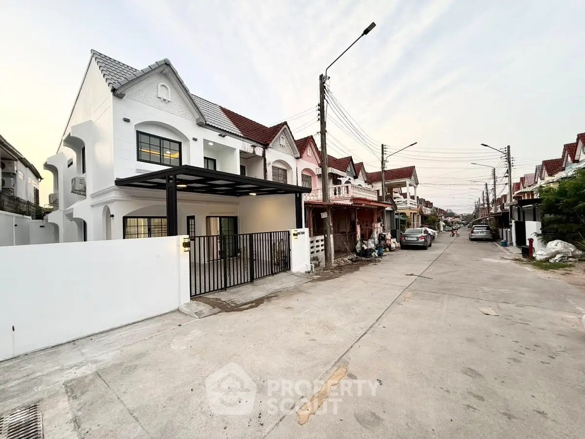 Charming suburban street with modern white house and gated entrance
