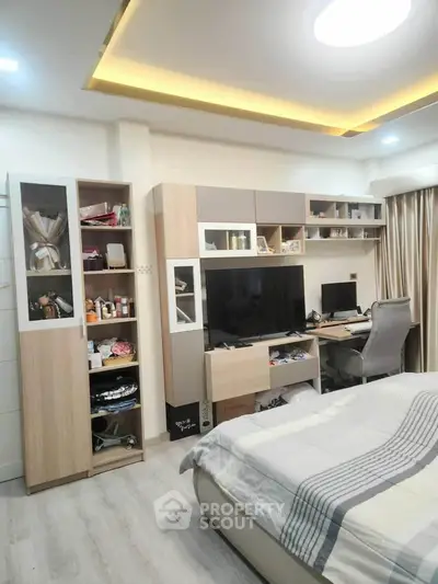 Modern bedroom with built-in storage and workspace, featuring sleek design and cozy ambiance.