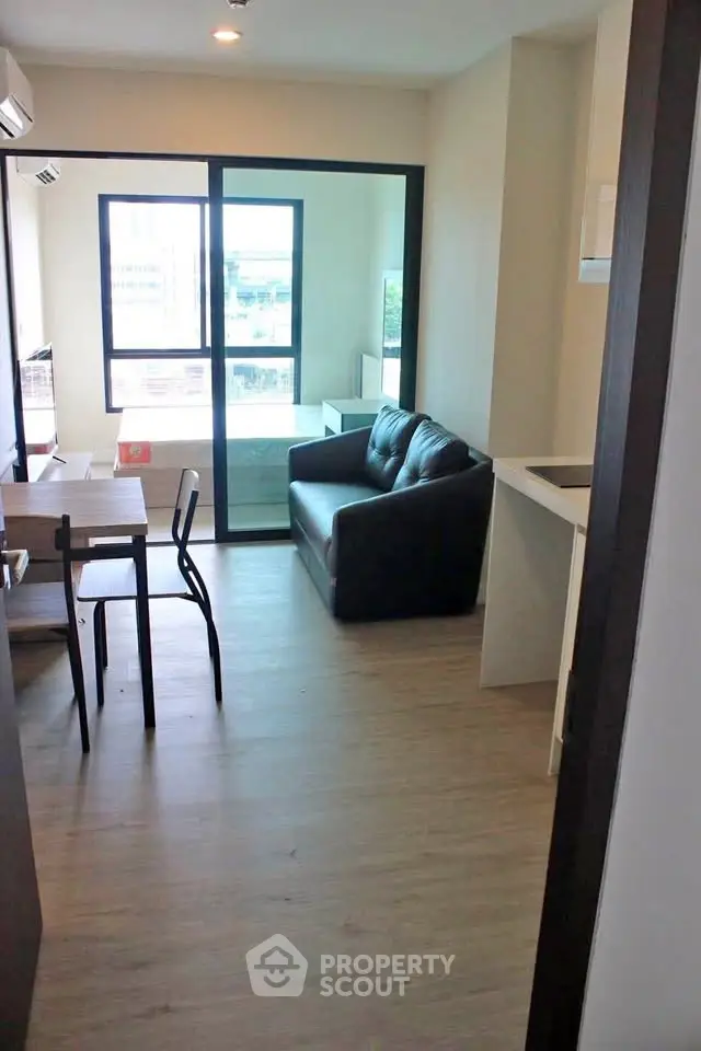 Modern living room with sleek furniture and large window in a stylish apartment.
