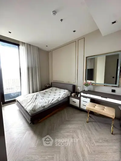 Elegant bedroom with modern decor and large window offering natural light