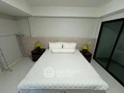 Cozy bedroom with modern decor and ample natural light, featuring a comfortable bed and stylish nightstands.