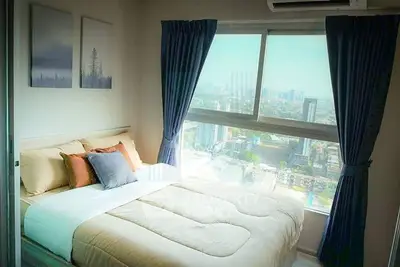 Cozy bedroom with city view and modern decor in high-rise apartment