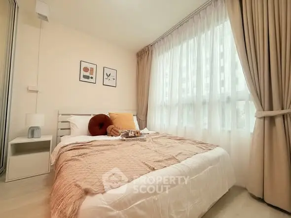 Cozy bedroom with large window and elegant curtains, perfect for relaxation and comfort.