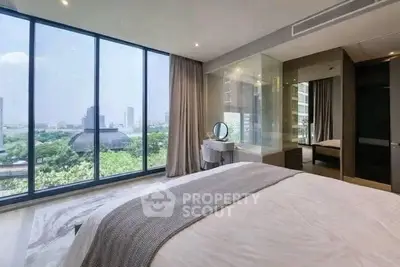 Luxurious bedroom with floor-to-ceiling windows offering stunning city views and modern decor.