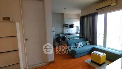 Modern living room with open kitchen and stylish furniture in a bright apartment.