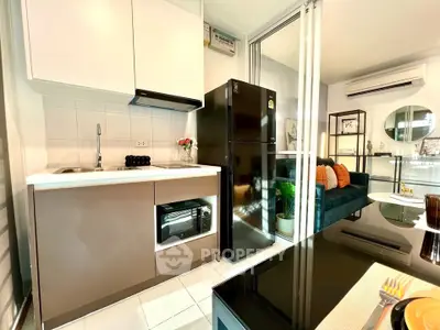 Modern kitchen with sleek appliances and open layout leading to cozy living room.