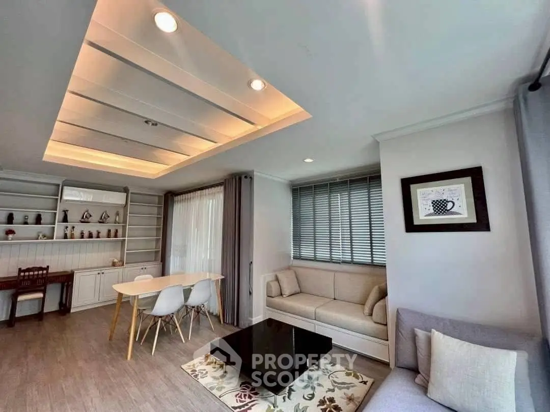 Spacious modern living room with elegant ceiling lights and cozy seating area.