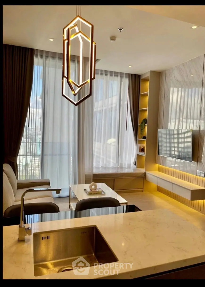 Modern living room with elegant lighting, open kitchen, and large windows offering a stunning view.