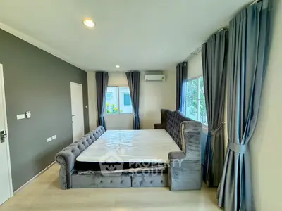 Spacious bedroom with elegant gray curtains and plush bed in modern apartment