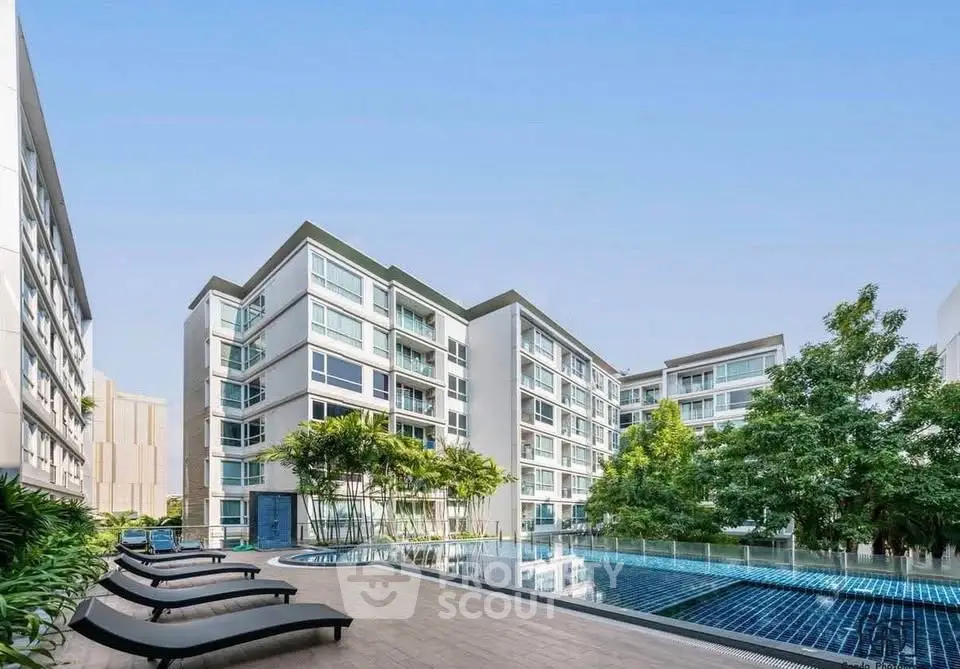 Modern apartment complex with pool and lush greenery, perfect for luxury urban living.
