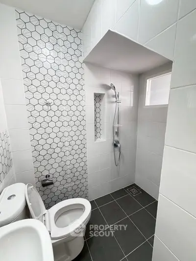 Modern bathroom with stylish hexagonal tile design and sleek fixtures.