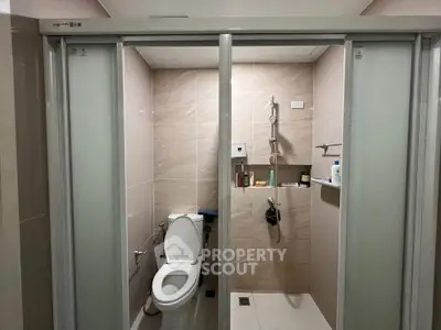 Modern bathroom with sliding glass doors and sleek fixtures.