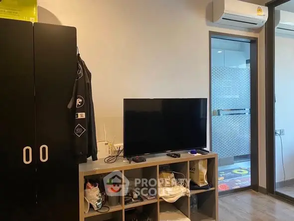 Modern living space with TV and air conditioning, featuring sleek storage solutions.